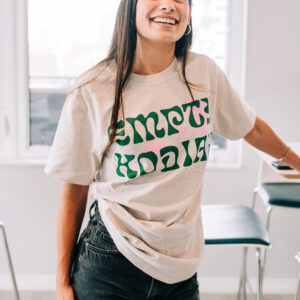 The Flower Power Camel Tee features a tan, premium-feel cotton body with a green Empty Kodiak logo in a floral-inspired font and a pink flower accent beneath. Comfortable, lightweight, and perfect for fans who want a warm, earthy vibe with a touch of color. Wear it to shows, weekend hangs, or anywhere you want to rep Empty Kodiak with style.